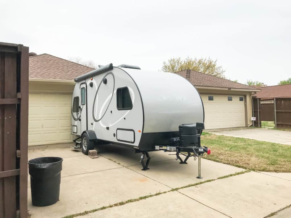 RV trailer parked at backyard of single family house, rear view